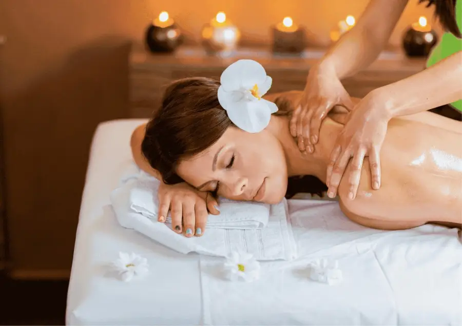 Guest relaxing during a Balinese massage with candles and an orchid