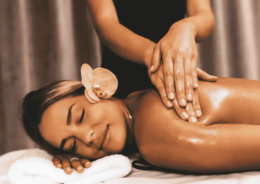 Guest with an orchid receiving a Lomi Lomi massage